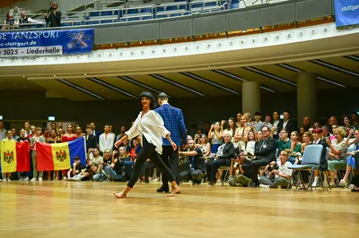 Dancesport competitor: Female dancer: white long-sleeved blouse and black pants