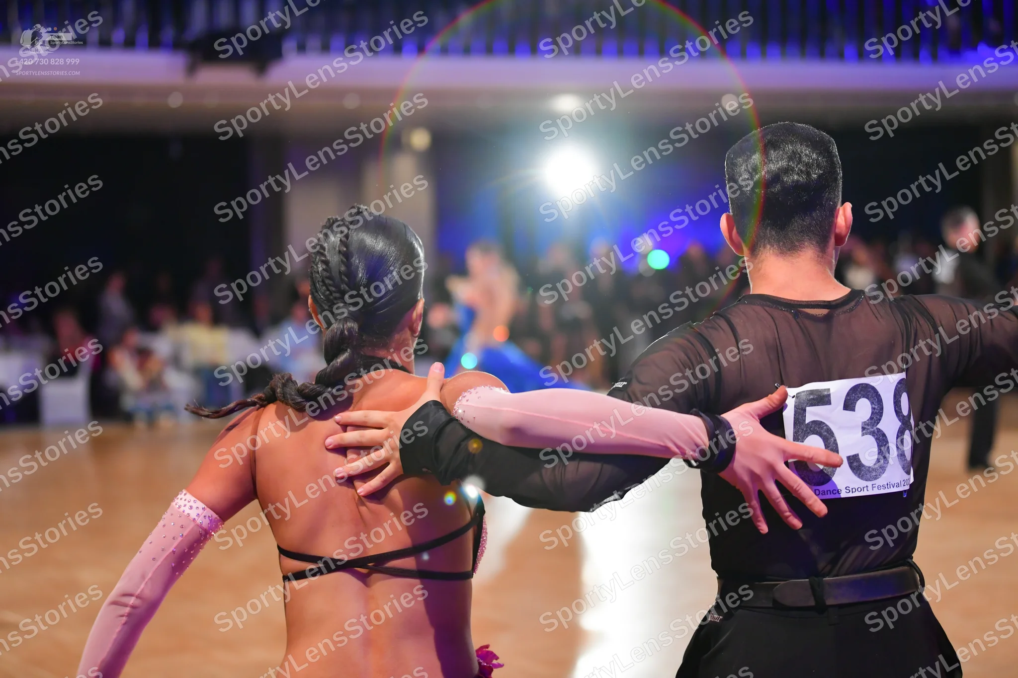 Dancesport competitor #538: Female dancer: black top with thin black straps and long, light pink sleeves