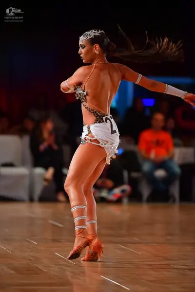 Dancesport competitor: Female dancer: nude-colored Latin dance costume with leopard print, white/silver