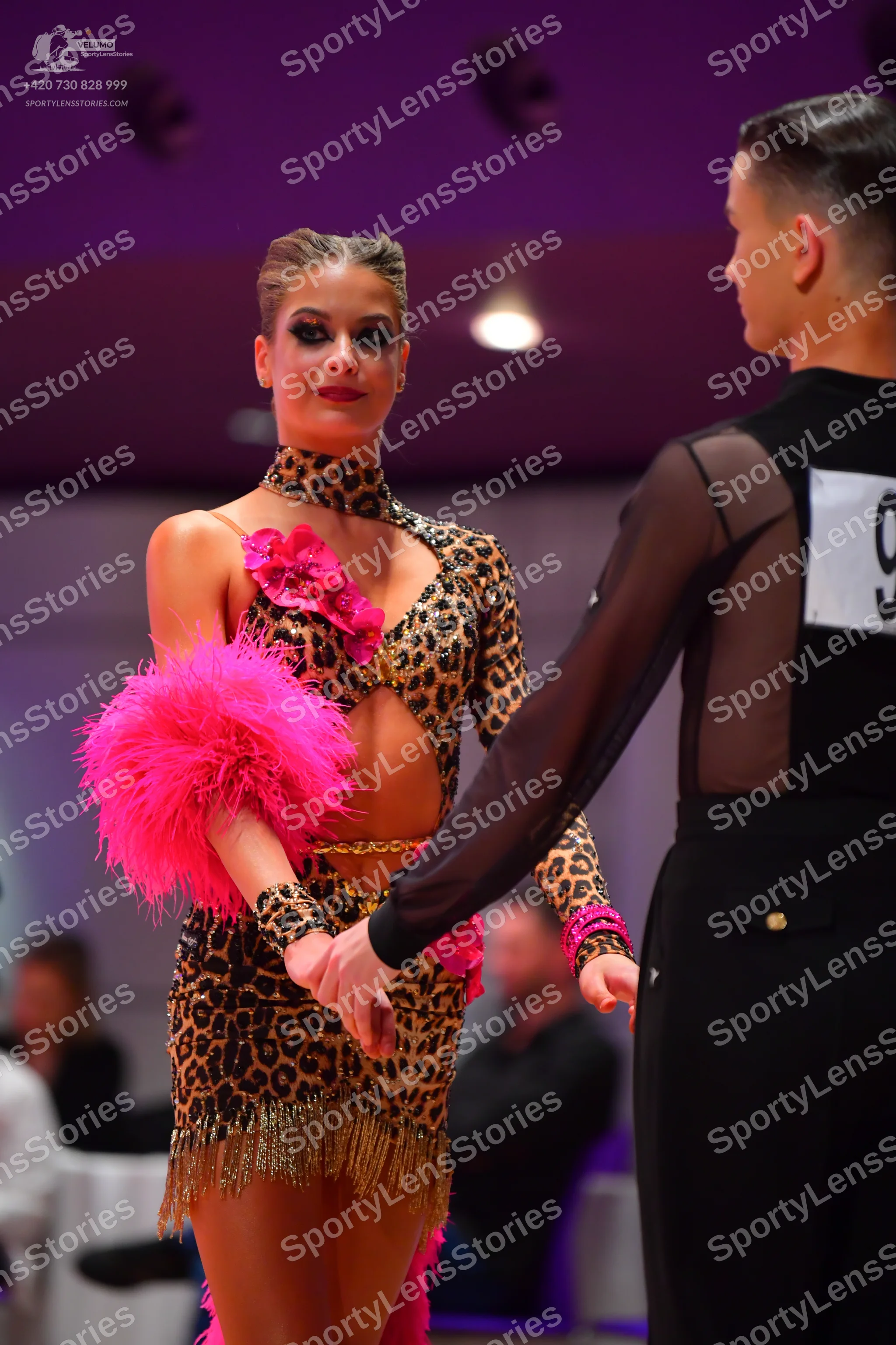Dancesport competitor: Male dancer: black latin dance top with sheer mesh sleeves and black trousers