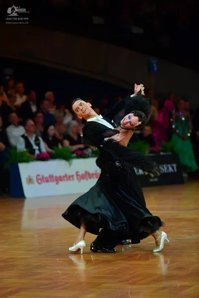 Dancesport competitor: Male dancer: black long-sleeved shirt with a white collar and black trousers