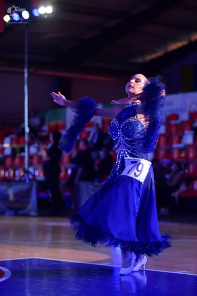 Dancesport competitor #79: Female dancer: blue sequined long dress with feather-like trim on the sleeves an