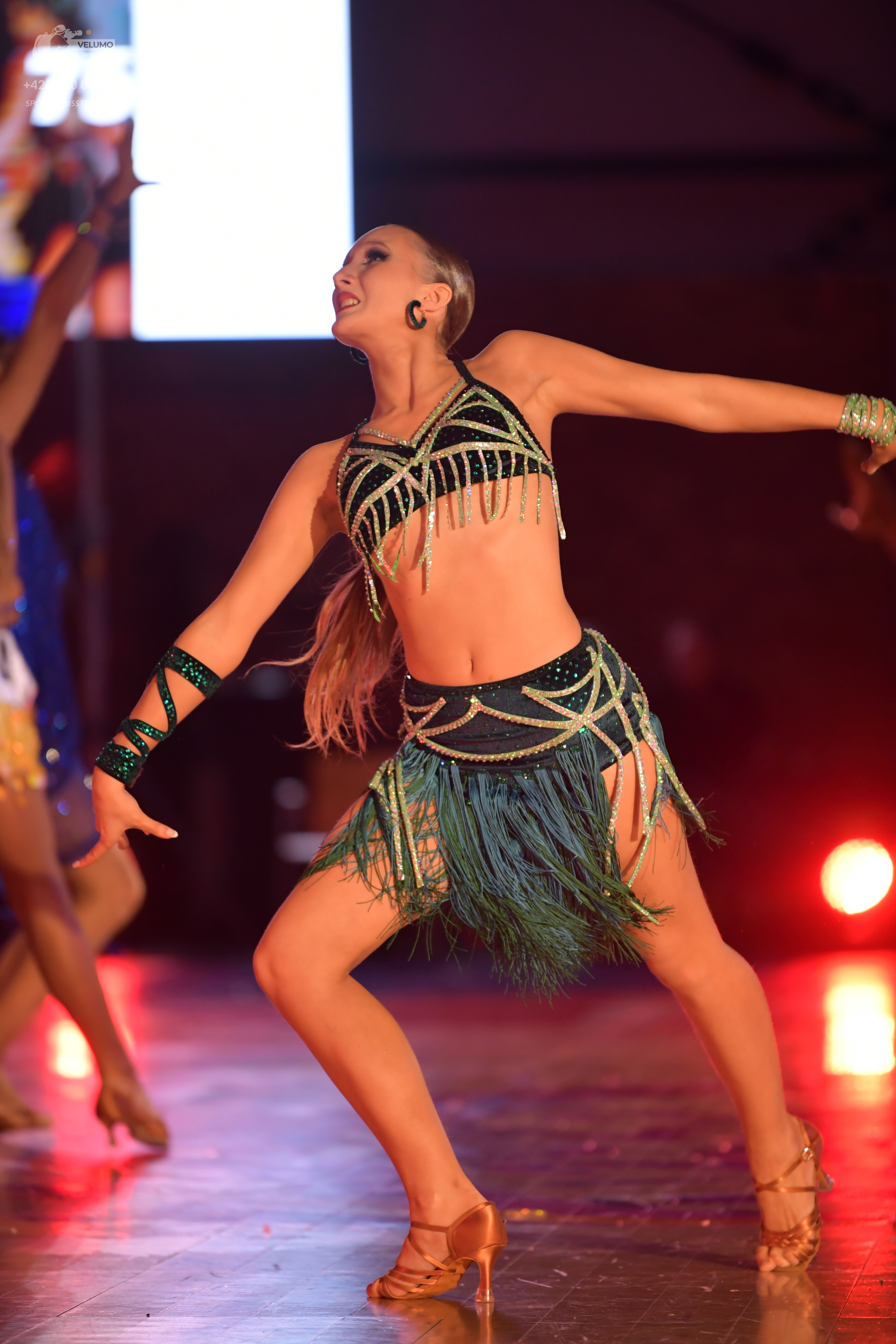 Dancesport competitor: Main dancer: emerald green two-piece Latin costume with gold/light green sequin 