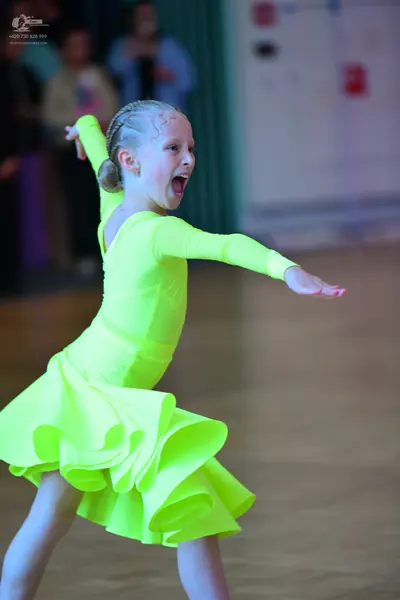 Dancesport competitor: Female dancer: bright neon yellow/lime green long-sleeved latin dress with a mul