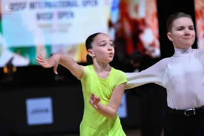 Dancesport competitor: Female dancer: lime green, short-sleeved, solid-colored Latin dress made of smoo