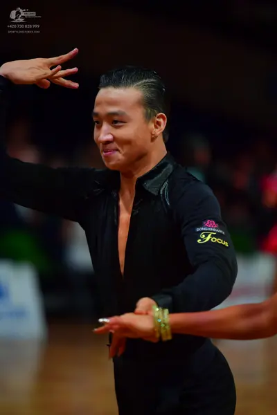 Dancesport competitor: Male dancer: black long-sleeved Latin dance shirt with shiny, textured lapels an