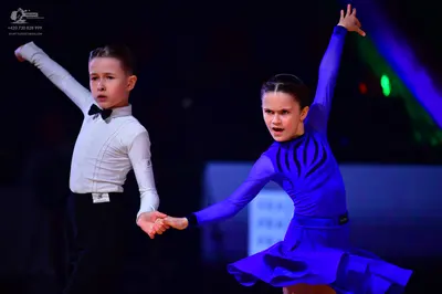 Dancesport competitor: Male dancer: white long-sleeved shirt, black bowtie, and black trousers