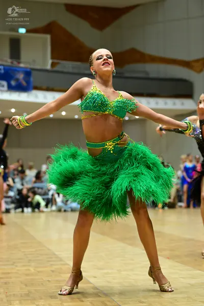 Dancesport competitor: Female dancer: green two-piece Latin costume with a sequined/beaded bra top and 