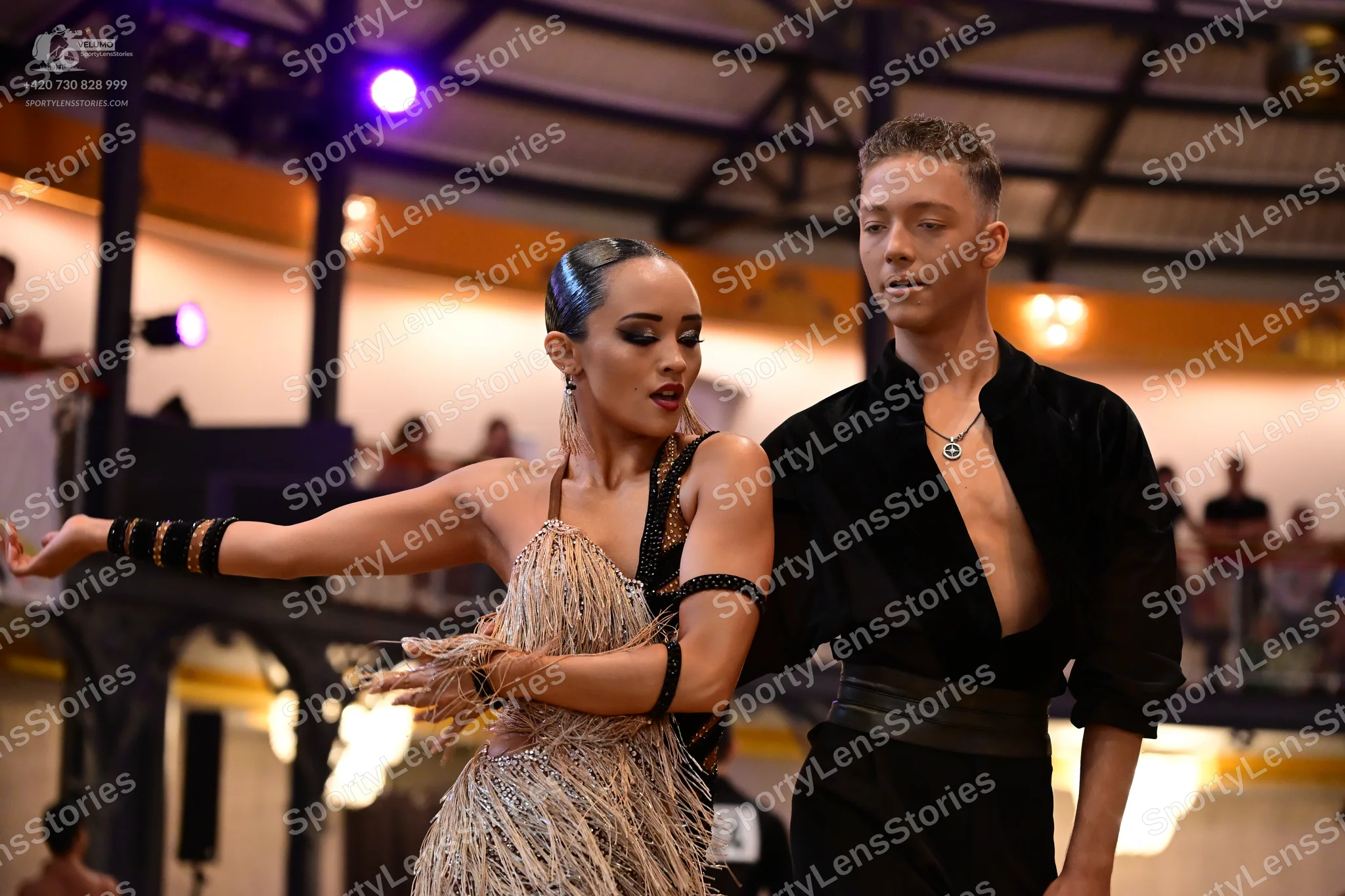 Dancesport competitor: Male dancer: black open-chested shirt, black trousers, and a silver pendant neck