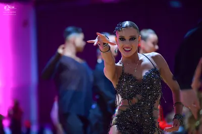 Dancesport competitor: Female dancer: black sequined and beaded latin dress with cut-outs and thin stra