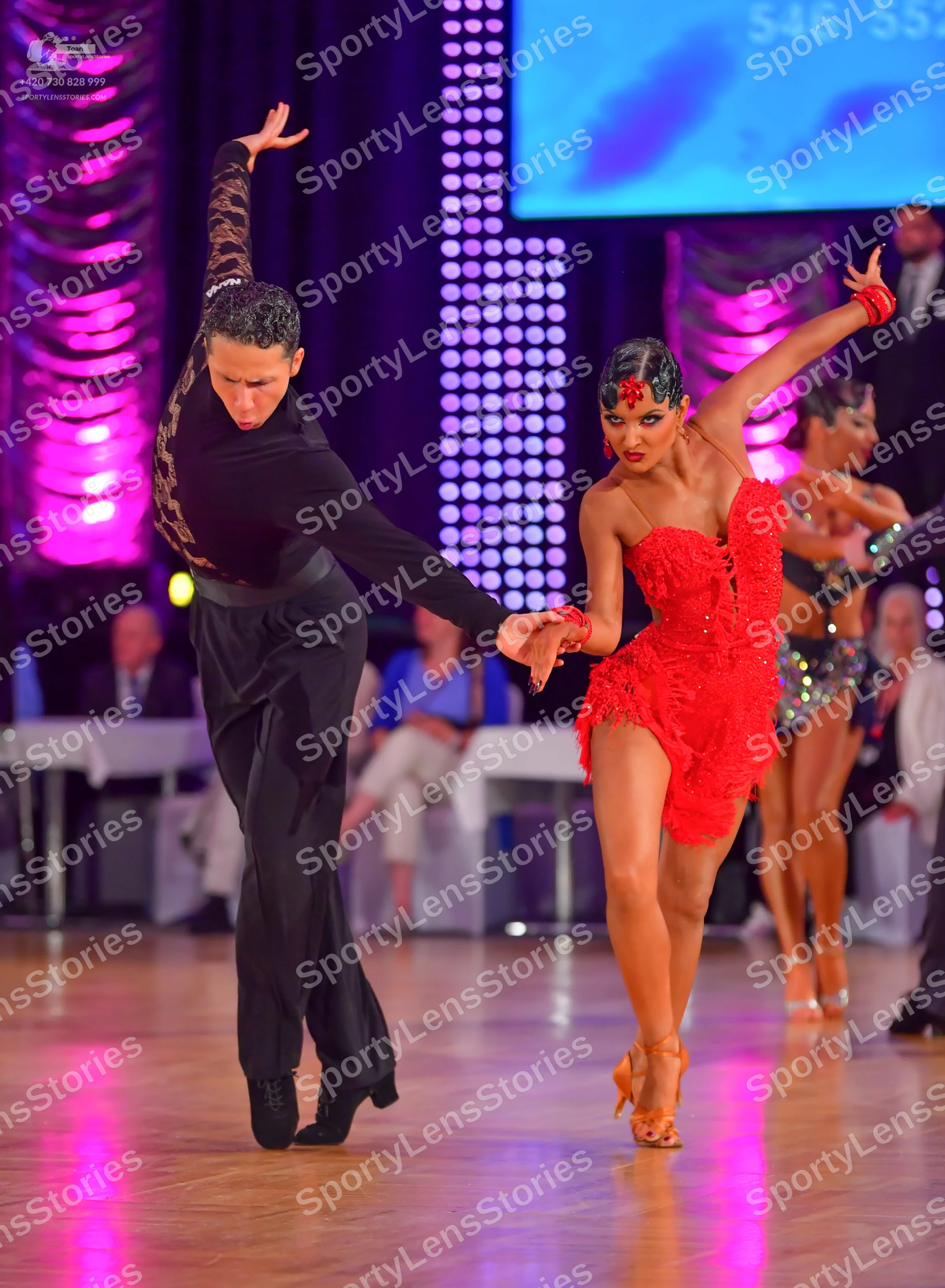 Dancesport competitor: Male dancer: black long-sleeved shirt with a patterned sleeve and black trousers