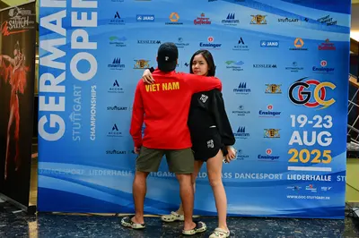 Dancesport competitor: Male dancer: red long-sleeved sweatshirt with "VIET NAM" in yellow on the back, 