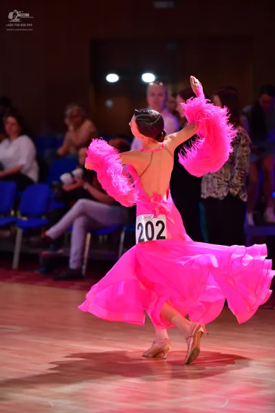 Dancesport competitor #202: Female dancer: bright pink ballgown with a voluminous skirt and large, fluffy pi