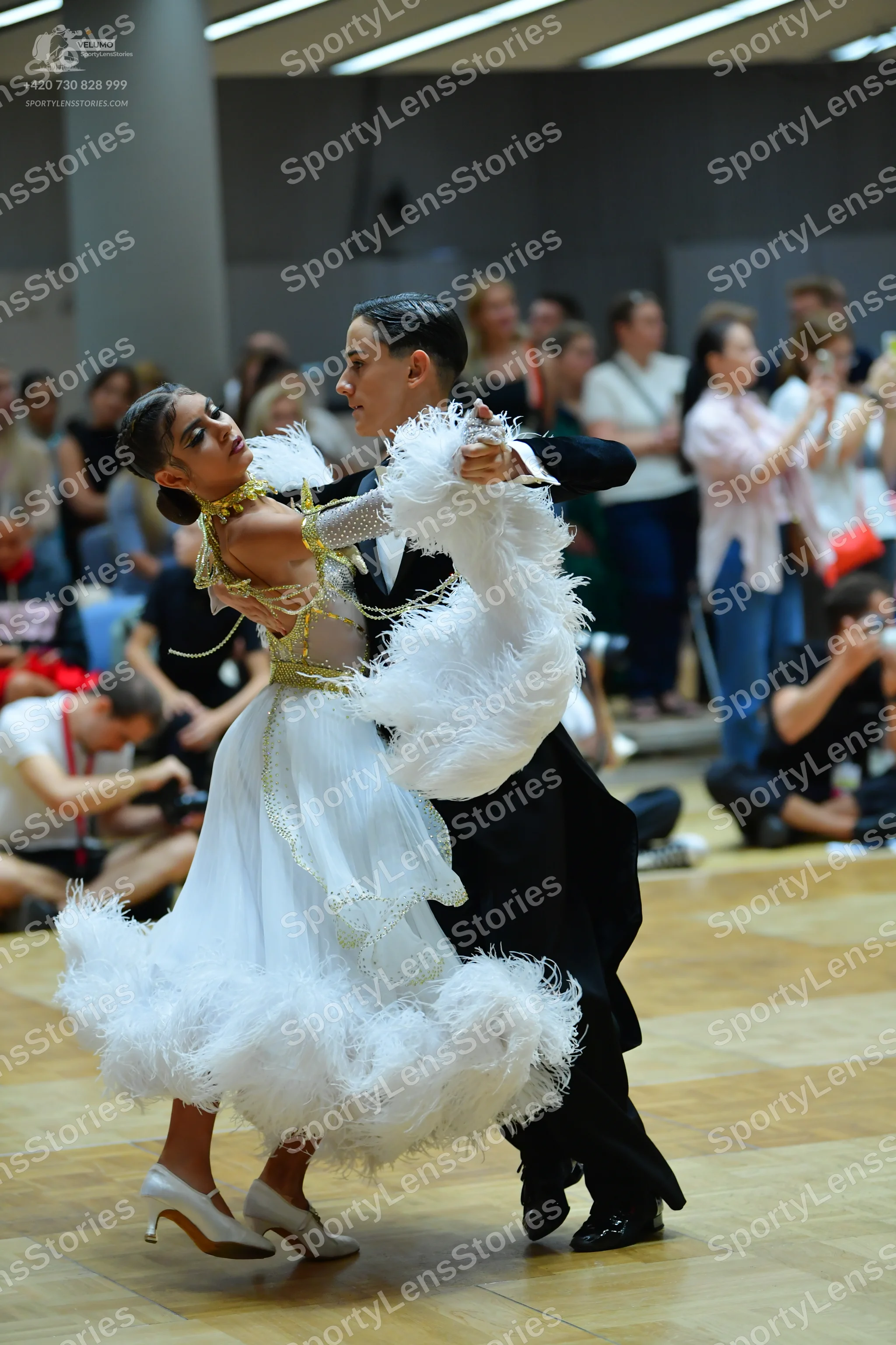 Dancesport competitor: Female dancer: white ballgown with gold sequin bodice and sleeves, featuring lar