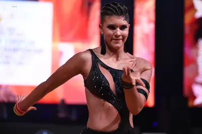 Dancesport competitor: Female dancer: black latin dance dress with sequin/crystal embellishments and cu