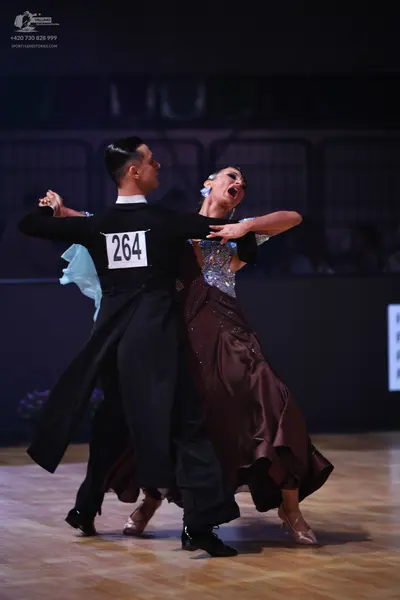 Dancesport competitor: Male dancer: black long-sleeved top with a white collar and black trousers