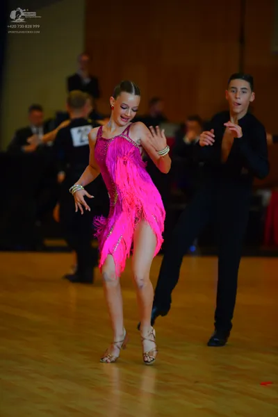 Dancesport competitor #25: Female dancer: pink latin dress with fringe and gold bangles
