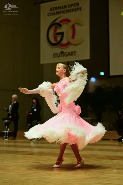Dancesport competitor: Here's a breakdown of the dancers' costumes in the image, based on your requeste