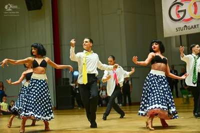 Dancesport competitor: Female dancers: black bra-style tops, white waistbands, and long navy blue skirt