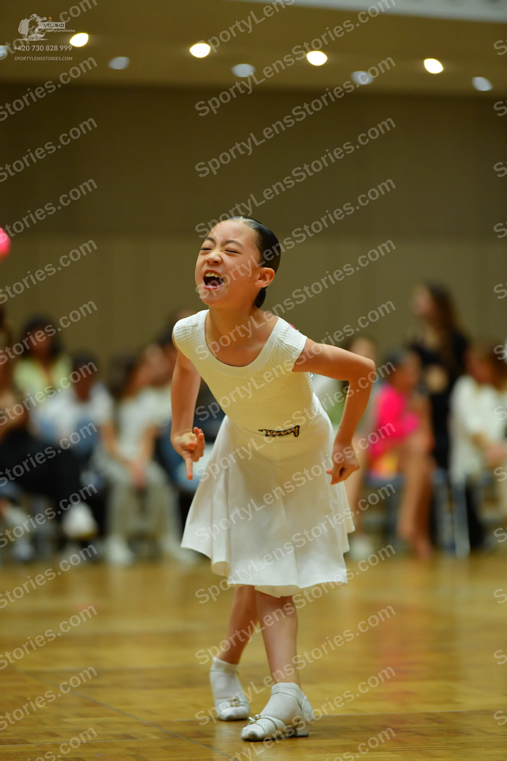 Dancesport competitor: Female dancer: white sleeveless dress with a flared skirt and white dance shoes