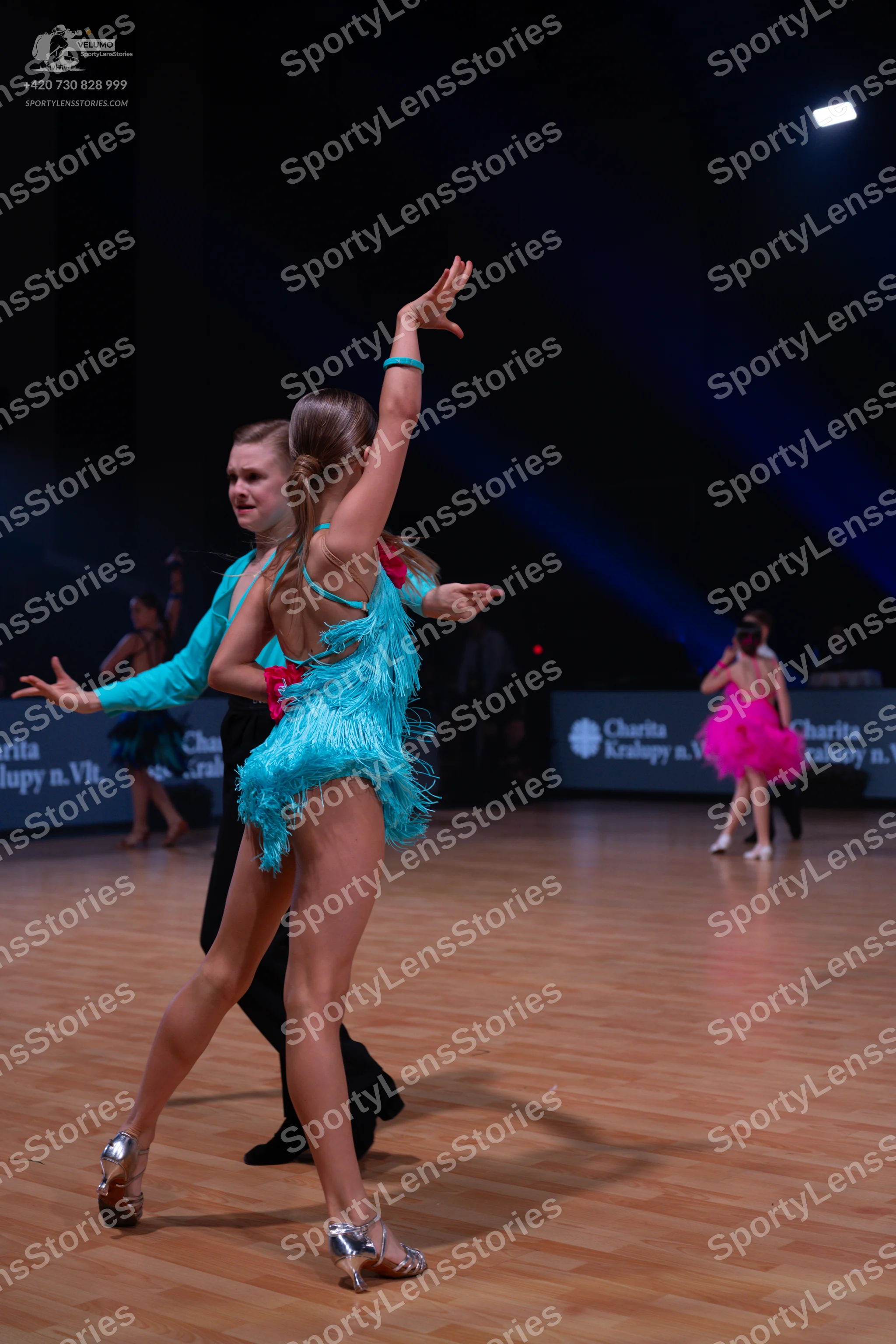 Dancesport competitor: Main female dancer: turquoise Latin dance dress with fringe and sequins