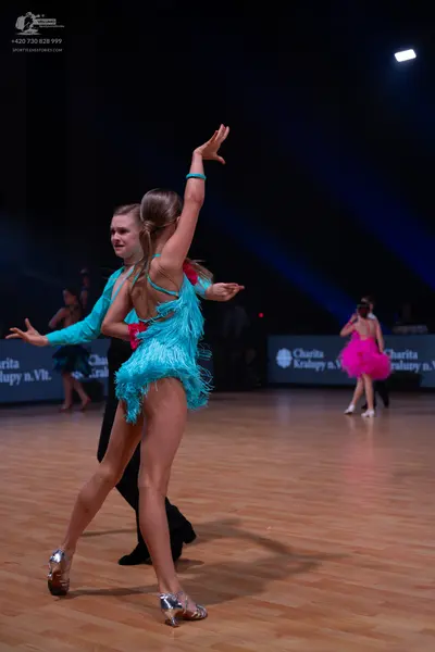 Dancesport competitor: Main female dancer: turquoise Latin dance dress with fringe and sequins