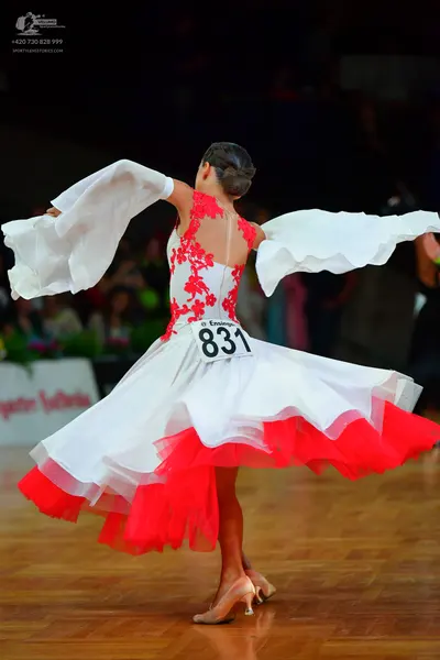 Dancesport competitor: Female dancer: white ballroom dress with red lace floral patterns on the bodice,