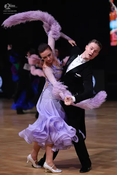 Dancesport competitor: Female dancer: light purple ballroom gown with a voluminous ruffled skirt and a 