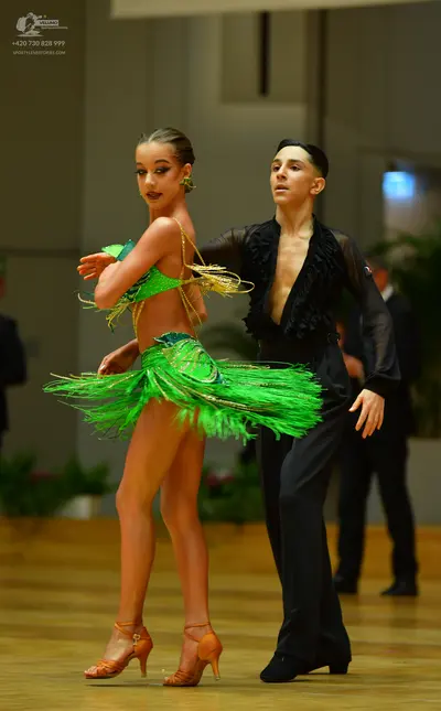 Dancesport competitor: Male dancer: black latin dance shirt with ruffled front and sheer sleeves, and b
