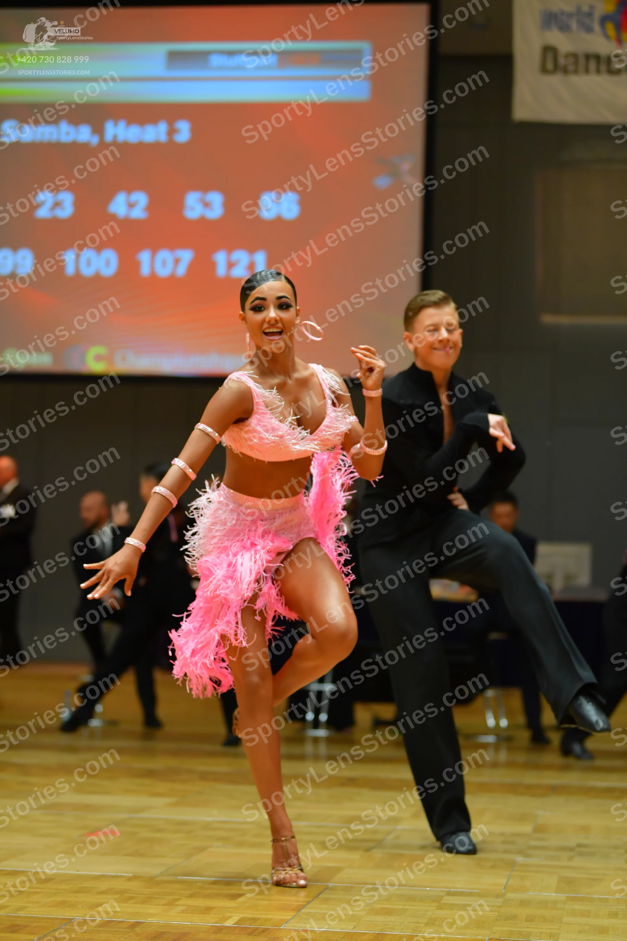 Dancesport competitor: Female dancer: pink latin dress with heavy fringe and large pink hoop earrings