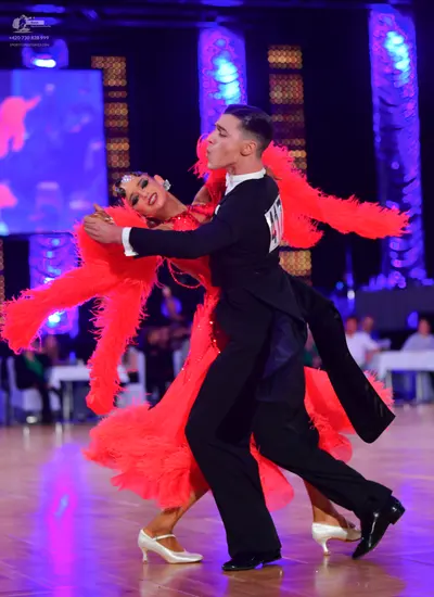 Dancesport competitor: Male dancer: black suit with a white shirt visible at the neck
