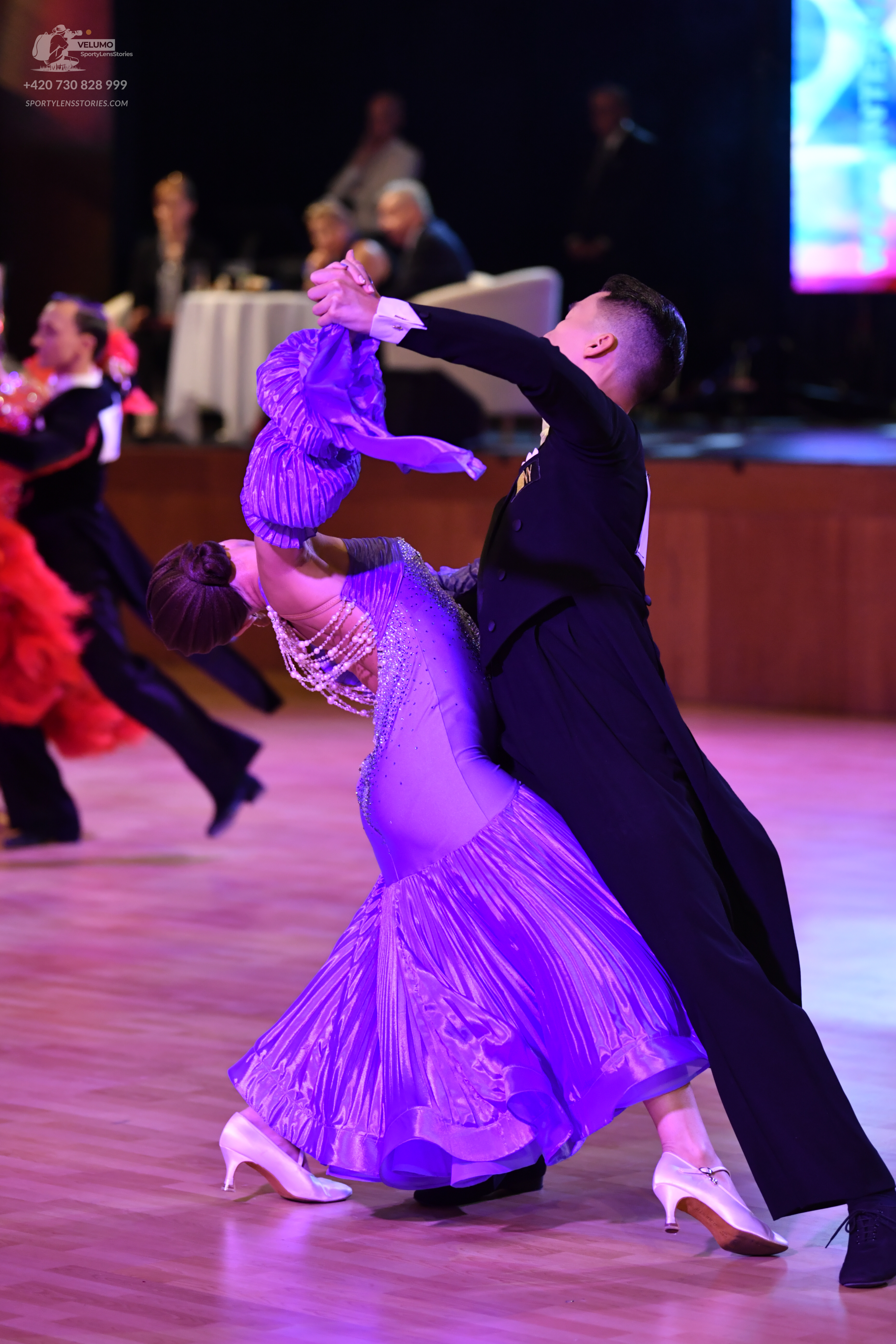 Dancesport competitor: Female dancer: purple satin ballroom dress with a full skirt and sparkling embel