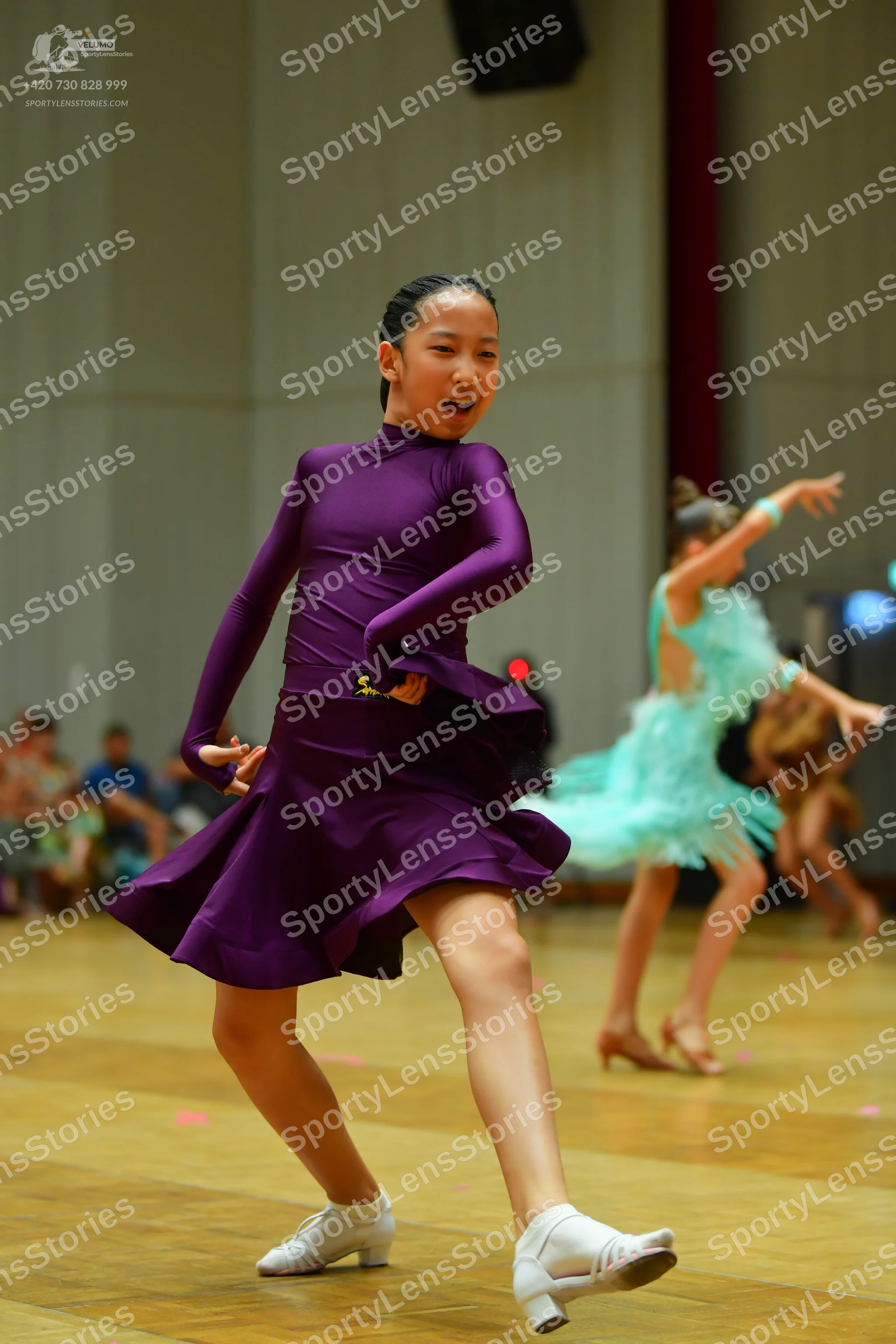 Dancesport competitor: Female dancer 1: purple long-sleeved latin dress