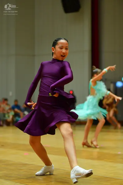 Dancesport competitor: Female dancer 1: purple long-sleeved latin dress