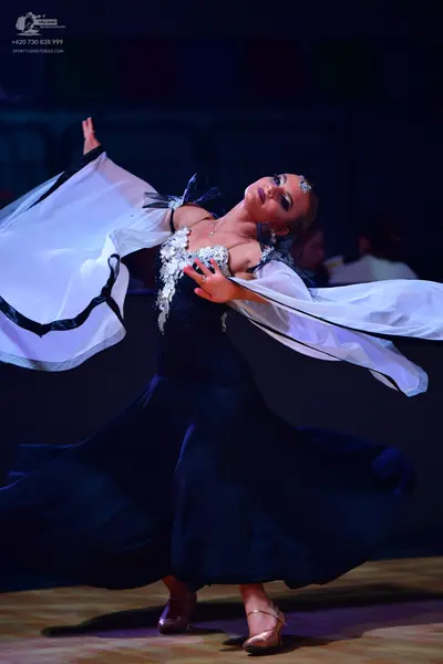Dancesport competitor: Female dancer: black ballgown with a silver sequined bodice and large, voluminou