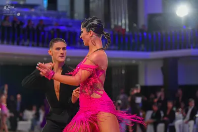 Dancesport competitor: Male dancer: black long-sleeved Latin dance top with a deep V-neck