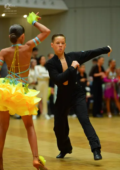 Dancesport competitor: Female dancer: bright yellow latin dress with a multi-layered ruffled skirt and 