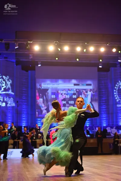 Dancesport competitor: Female dancer: light blue and mint green voluminous ballgown with many ruffled a