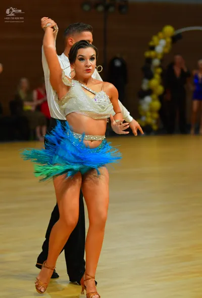 Dancesport competitor: ** Red Latin dress
*   **Fabric:** Appears to be satin with a fringe detail