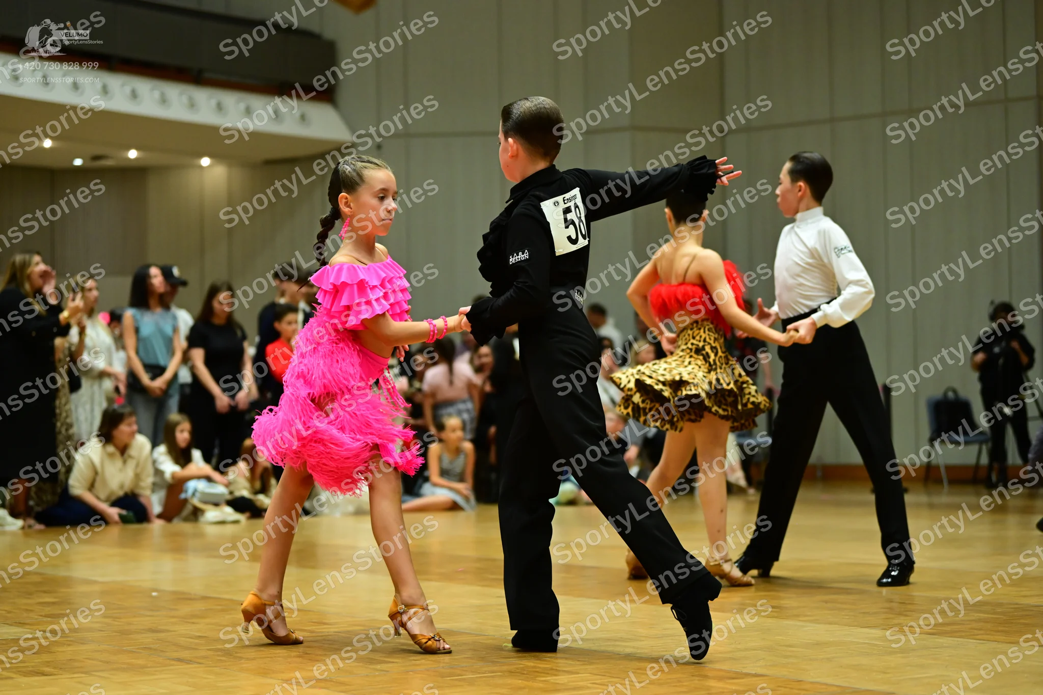 Dancesport competitor #58: Female dancer in foreground: bright pink ruffled latin dress
