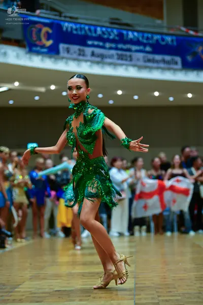 Dancesport competitor: Female dancer: green latin dress made of sequin and lace fabric with a halter ne