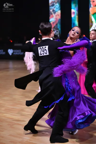 Dancesport competitor: Male dancer (foreground): black ballroom tailcoat, white shirt, and black trouse