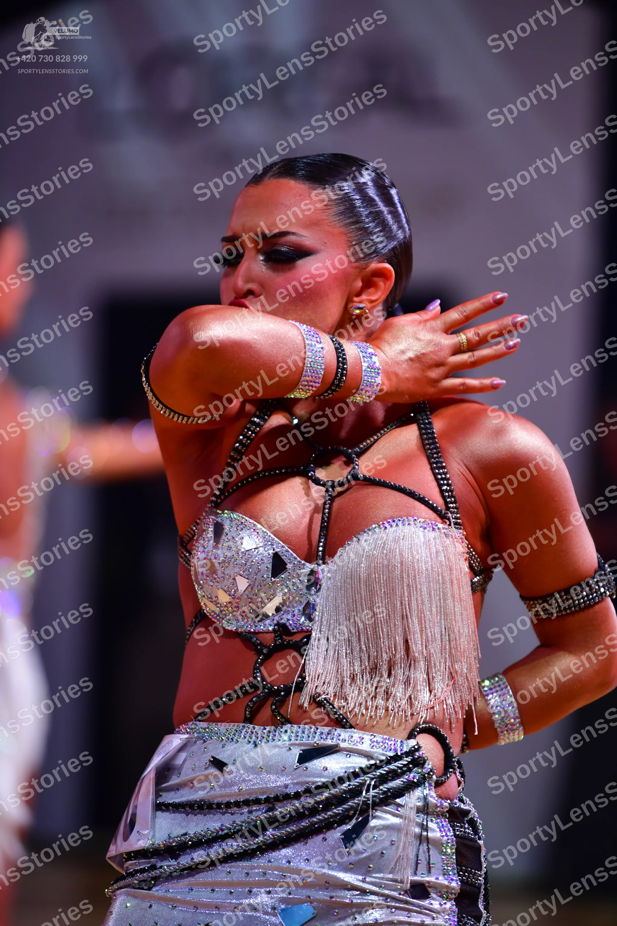 Dancesport competitor: Female dancer: silver/metallic Latin dance costume with a sequined top featuring