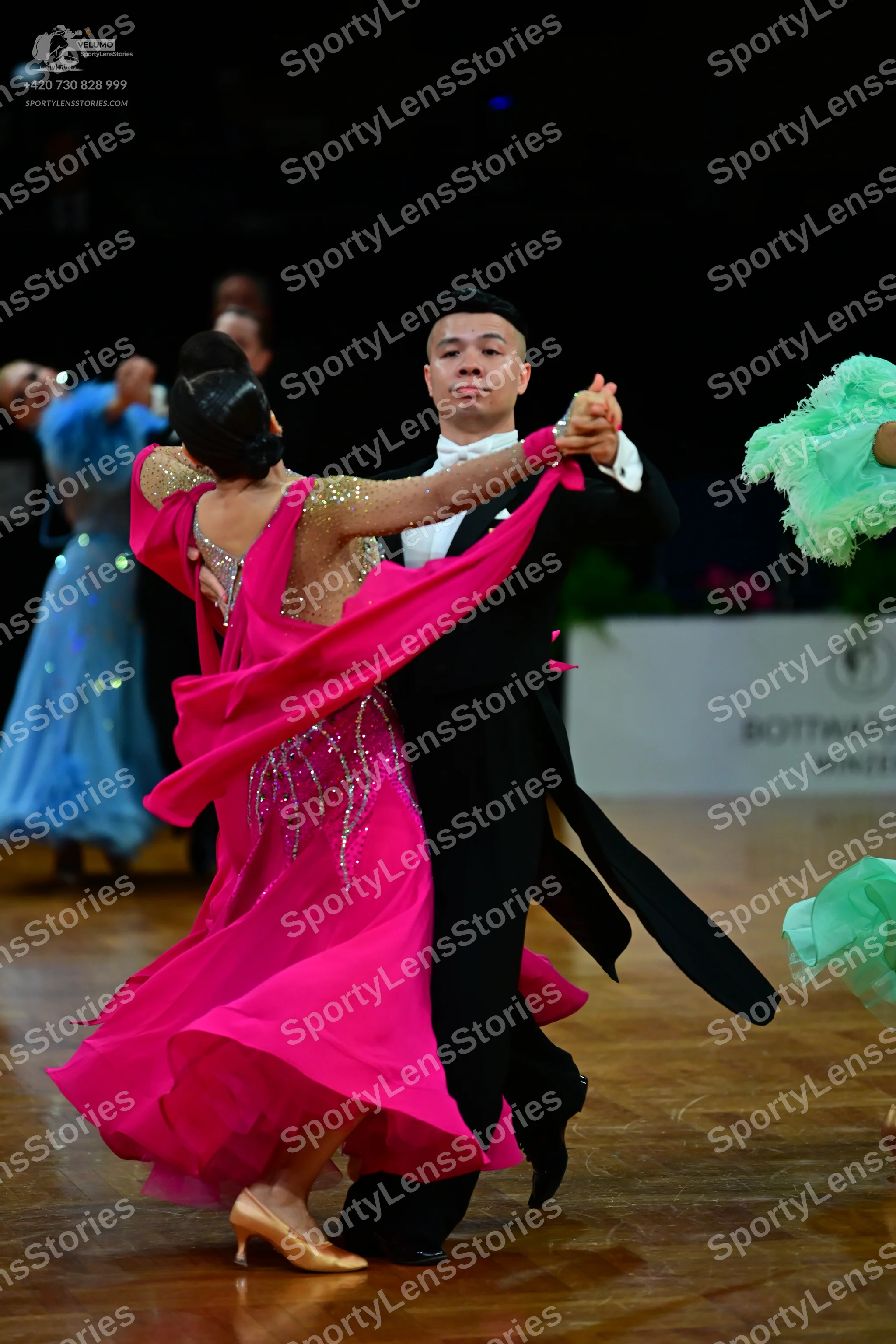 Dancesport competitor: Central female dancer: bright pink ballroom gown with a sequined bodice