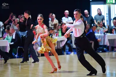 Dancesport competitor: Female dancer: gold sequined latin dress with thin straps and a short skirt