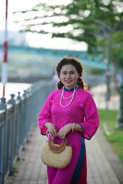 Dancesport competitor: Female dancer: bright pink long-sleeved lace dress with blue trim on the cuffs a