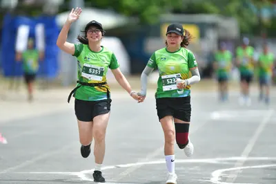 Marathon runner #5351, #5237: Runner 1: green jersey, black shorts, black shoes, black cap, black waist belt