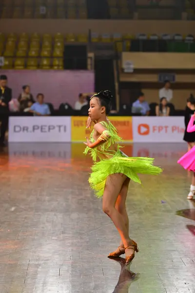 Dancesport competitor: Female dancer: lime green Latin dance dress with fringe