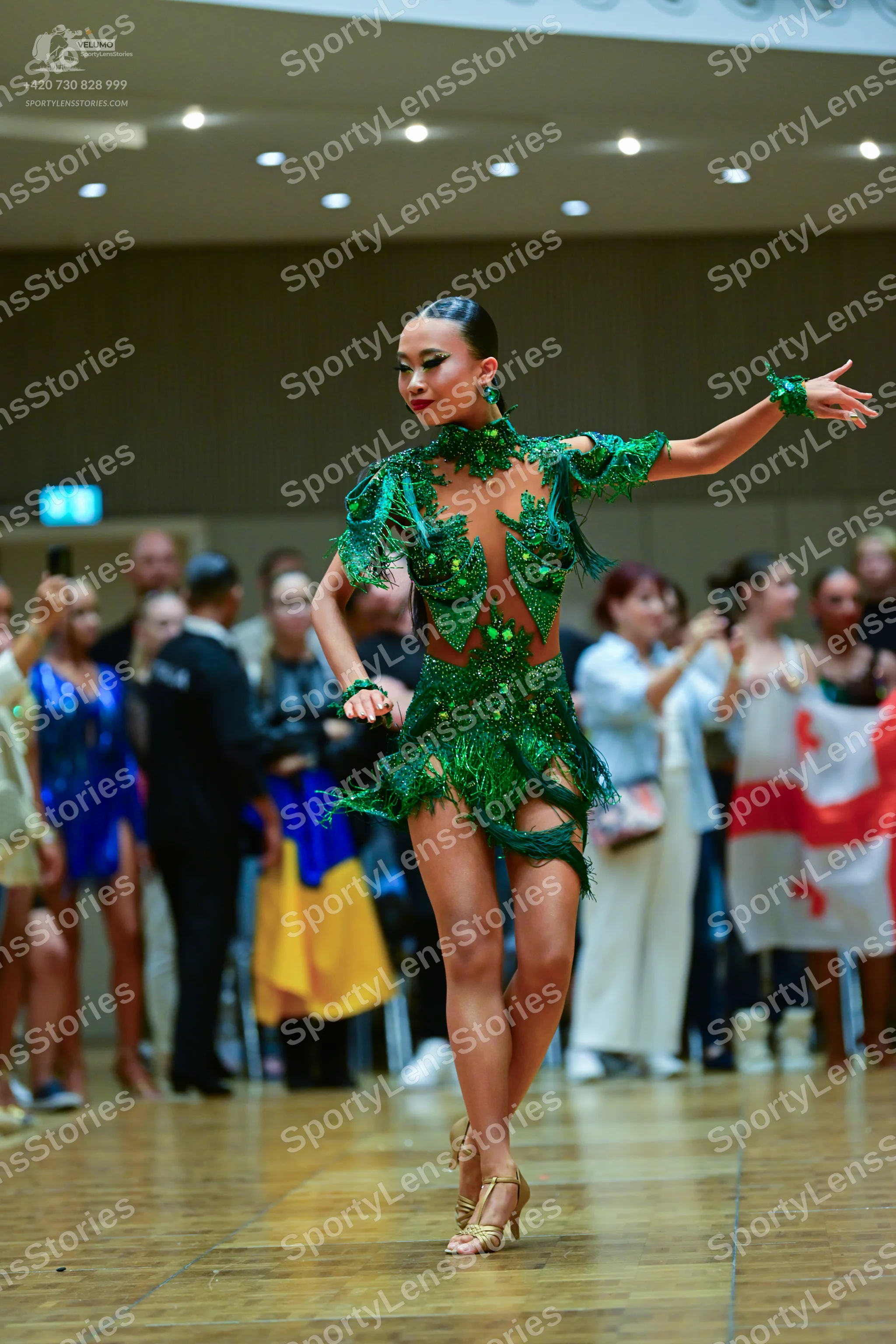 Dancesport competitor: Main dancer: emerald green latin dress with sequins, beads, and nude mesh, long