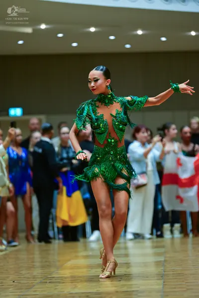 Dancesport competitor: Main dancer: emerald green latin dress with sequins, beads, and nude mesh, long 